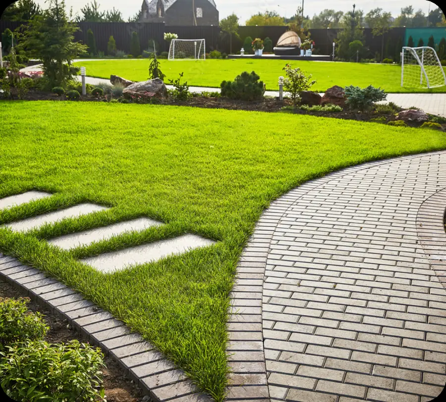 Curved brick walkway across a green lawn