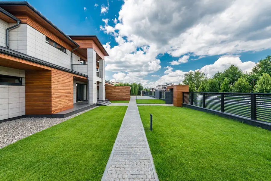 Fresh lawn and stone path beside a modern home