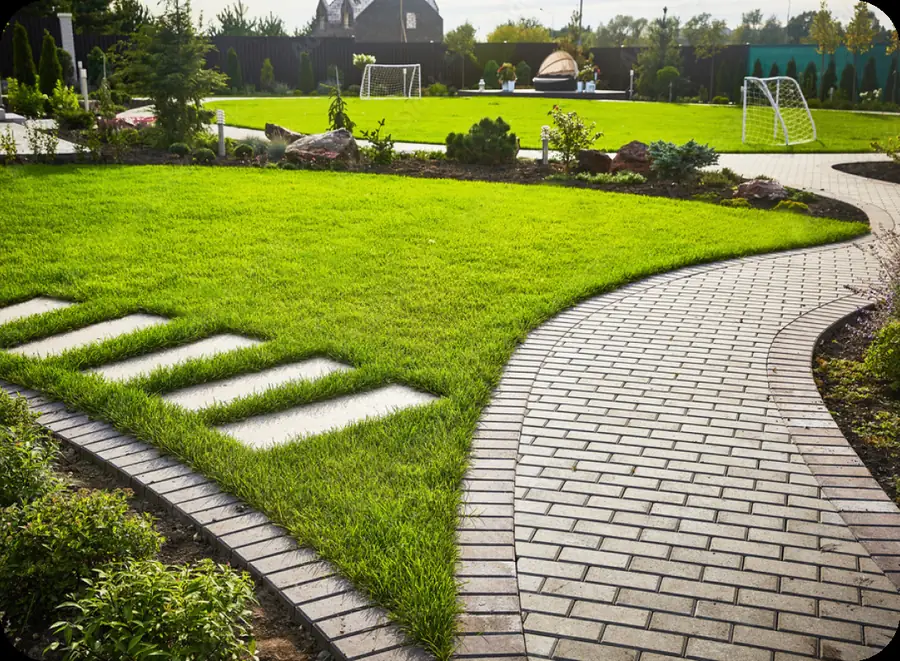 Brick walkway across a green lawn